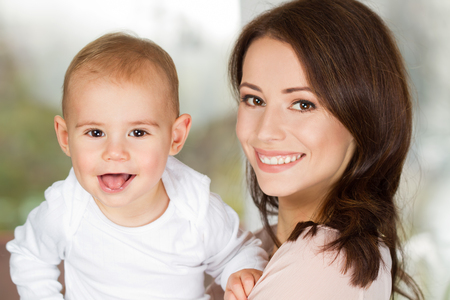 Portrait of gorgeous young mother with her infant child.の写真素材
