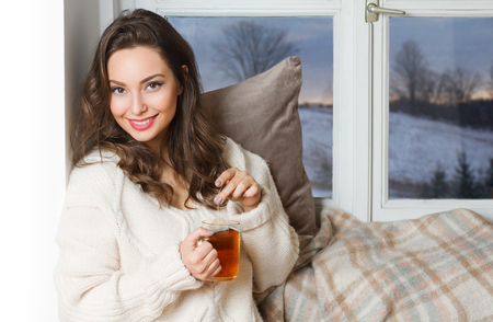 Gorgeous young brunette woman holding cup of hot beverage.の写真素材