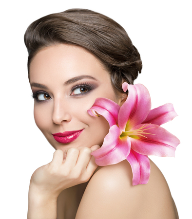 Portrait of a brunette beauty holding colorful flower.の写真素材