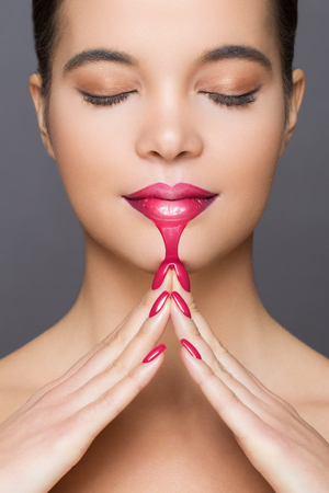 Gorgeous young brunette woman in makeup, ombre lipstick with liquid drip effect.の写真素材