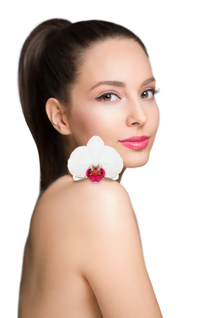 Brunette beauty in light makeup holding colorful flower.の写真素材