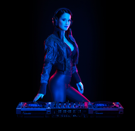 Gorgeous young female DJ in colorful stage lighting.の写真素材