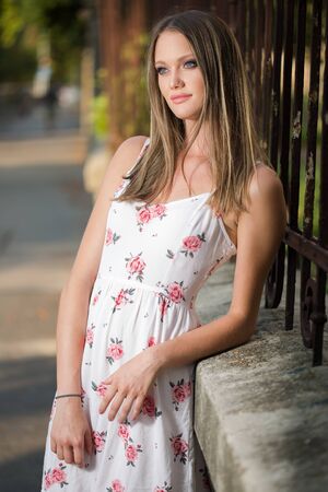 Outdoors portrait of a blond beauty in white summer dress.の写真素材