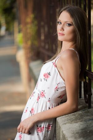 Outdoors portrait of a blond beauty in white summer dress.の写真素材