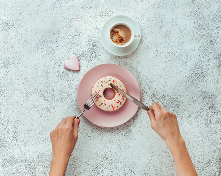 Breakfast concept: donut shape biscuit on white stone background; top view flat layの写真素材