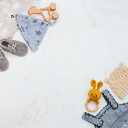 Newborn baby clothing and beanbags on marble background with copy spaceの写真素材