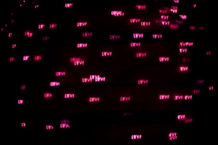 Abstract romantic background of defocused bokeh with word love, on black backgroundの写真素材