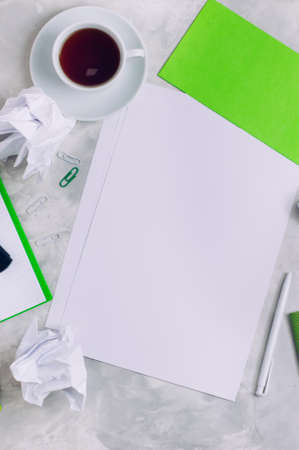 Empty white paper and cup of coffee over concrete background with copy space: top view.の写真素材