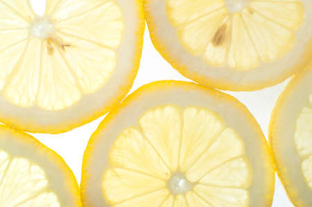 Close up of fresh yellow citrus lemon slices with back lightの写真素材