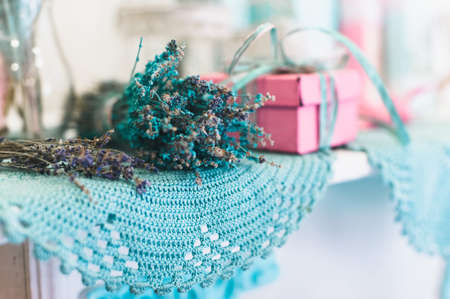 Vintage decoration with lavender flowers bouquet on the on the blue round crocheted napkin; shot in...