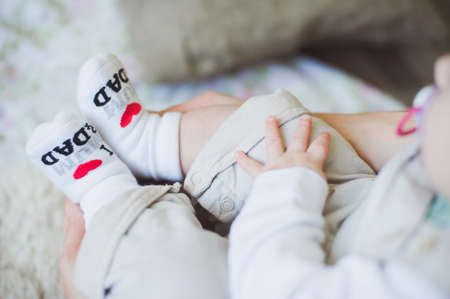 Close up view of baby feet in socks with funny inscription "I love mum & dad"; shot in shallow depth of fieldの写真素材
