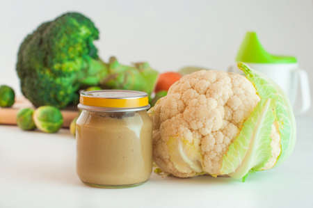 Glass jar with natural baby food vegetable puree with cauliflower; selective focusの写真素材