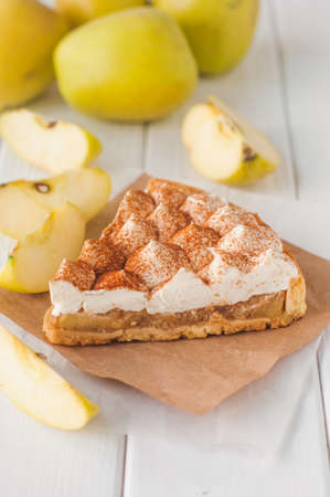 A piece of apple pie with whipped cream covered by grated chocolate near yellow apples. Selective focus and small depth of field ..の写真素材