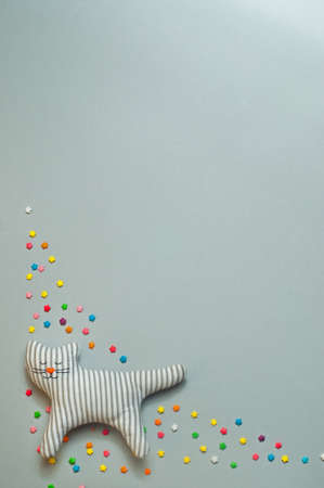 .Funny textile cat toy with closed eyes, over gray background with copy space; top view, flat lay ..の写真素材
