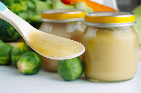 Spoon with natural baby food on the table: vegetable puree with Brussels sprouts; selective focus.の写真素材