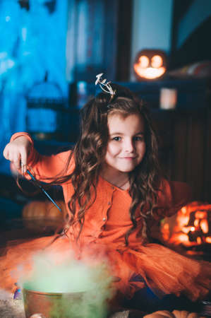 Little girl in a costume of witch with magic wandの写真素材
