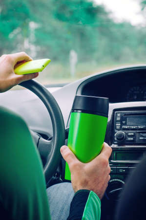 Man holding thermo mug and smartphoneの写真素材