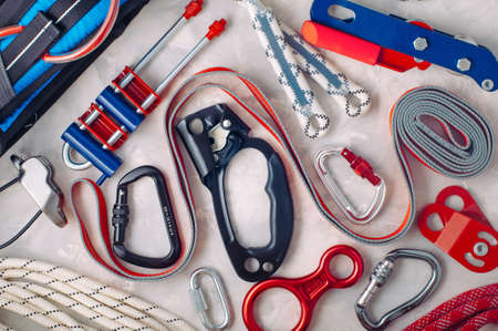 Personal safety equipment using in Climbing, Urban climbing, working on height, Speleology, Alpinism, over gray concrete background: lifting and pulley devices, rope, the station loop, pulley, figure eight descender, carabiner, single rope descender and ascender; top view, flat layの写真素材