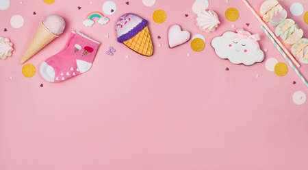 Cute Happy Birthday party background: Ice cream cone, gingerbreads and marshmallows on the pink background with blank space for text top view, flat layの写真素材