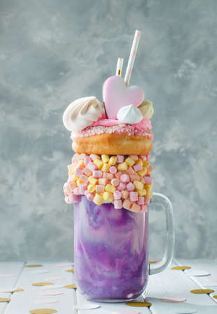 Freak shake topping with donut, marshmallow, meringue on gray background selective focus.の写真素材