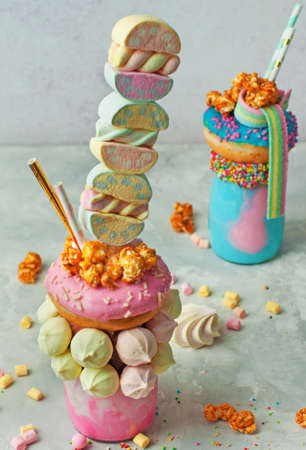 Happy Birthday party background: Freak shake topping with donut, marshmallow, meringues, popcorn and marmalade over gray background selective focus.の写真素材