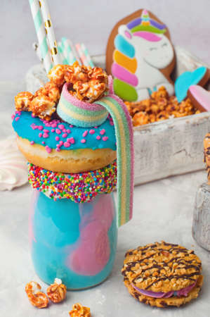 Happy Birthday party background: Freak shake topping with donut, popcorn and marmalade over gray background selective focus.の写真素材