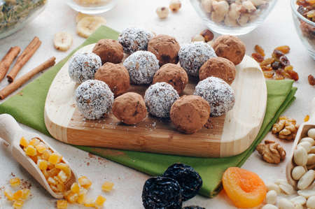 Homemade vegan candies from dried fruits, nuts and chickpeas covered with cocoa powder and coconut...