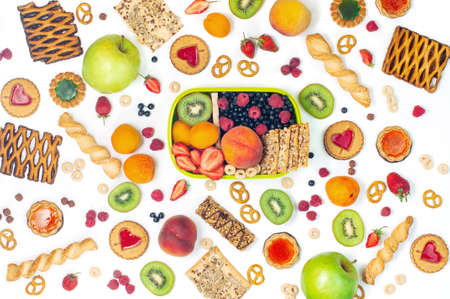 Summertime healthy food concept: Lunch box and variety of fruits, berries, cookies and crunches...