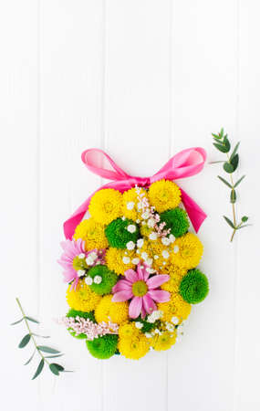 Easter egg from flowers on white wooden backgroundの写真素材