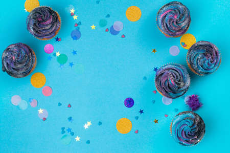 Vanilla cupcakes with galaxy dark whipped cream on party background with blank space for textの写真素材