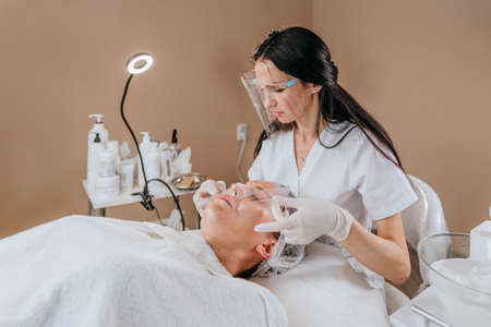 Esthetician or facialist making facial cleansing procedureの写真素材