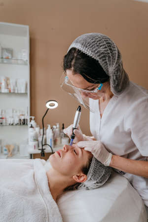 Close-up of an esthetician making facial cleansing procedure
