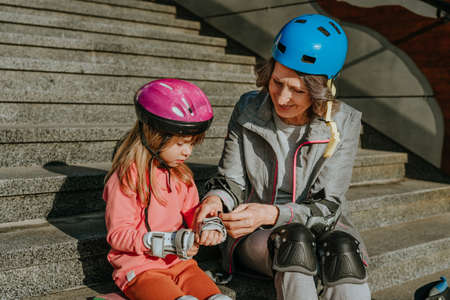 Grandmother and granddaughter are preparing for roller skatingの写真素材
