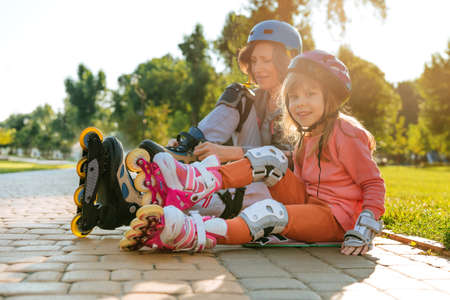 Grandmother and granddaughter are preparing for roller skatingの写真素材
