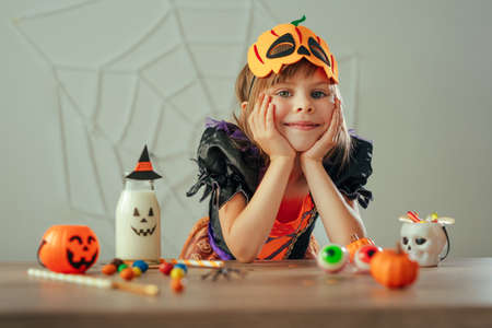 Portrait of little girl dressed Halloween witch costume and pumpkin maskの写真素材