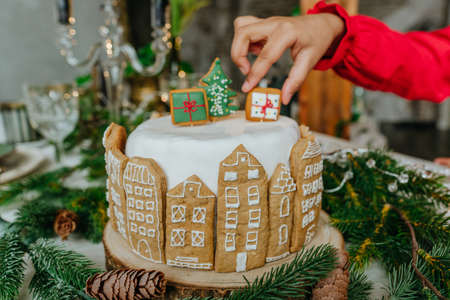 Close up of Christmas cake decorated with handmade house gingerbreads. Selective focus on the cake.の写真素材
