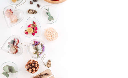DIY ornaments filled with dried flowers on white background with blank space for text. Christmas decor idea. Top view, flat lay.の写真素材