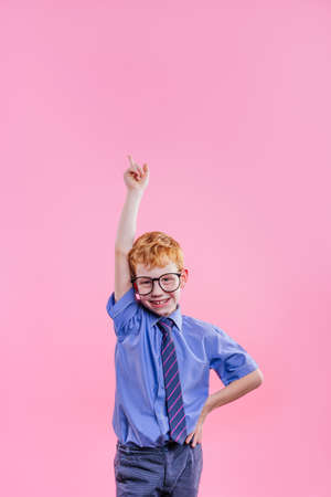 Little girl holding clock pointing on it on blue background with blank space for text. Horizontal panoramic banner.の写真素材