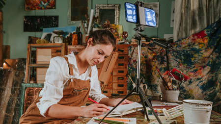 Creative blogger recording online art lesson at workshop making virtual video tutorial