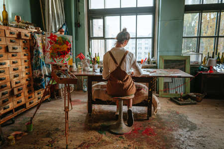 Backview of female artist working at her studioの写真素材