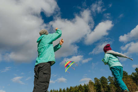 Father with his 5 years old daughter prepairing kite to fly. Happy family activities outdoor. Parenthood concept.の写真素材