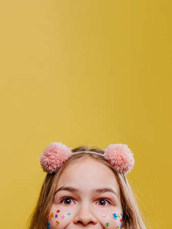 Funny teenage girl with stickers on her face wearing pink fluffy hair hoodの写真素材