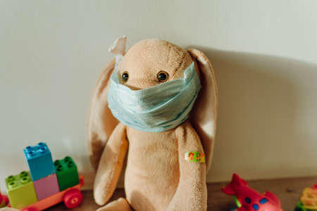 Soft toy bunny with medical tape plaster on the shoulder after injectionの写真素材