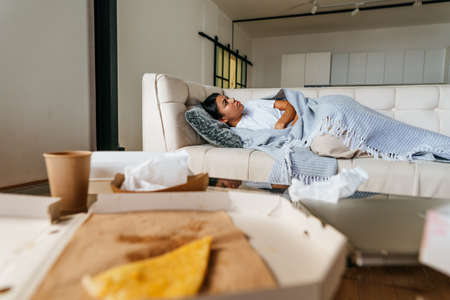 Young woman lying on the sofa in the living roomの写真素材