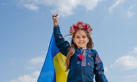 Girl wearing national clothes and wreath holding flag of Ukraineの写真素材