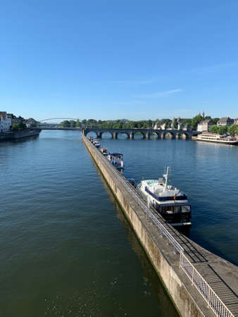 City skyline with boats at Meuse (Maas) river and Augustijnen church in Maastricht, the Netherlands.