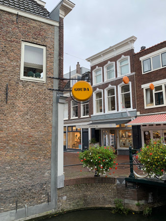 Sign of the cheese store at the Gouda city centre with old houses in the background. Gouda, South Holland / Netherlands.のeditorial素材