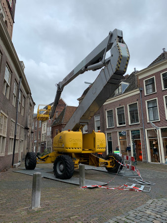 Manlift crane (telescopic boom lift) used as aerial work platform parked next to the building at...