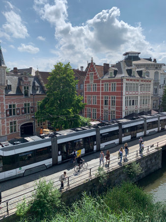 Tramway is crossing historical Ghent city old town. Belgian public transport. Ghent, East Flanders,...