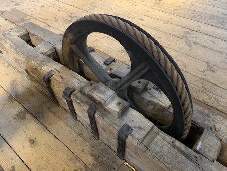 Old metal pulley fixed on the wooden floor at the the medieval ages tower St. Rumbold's Cathedral,...